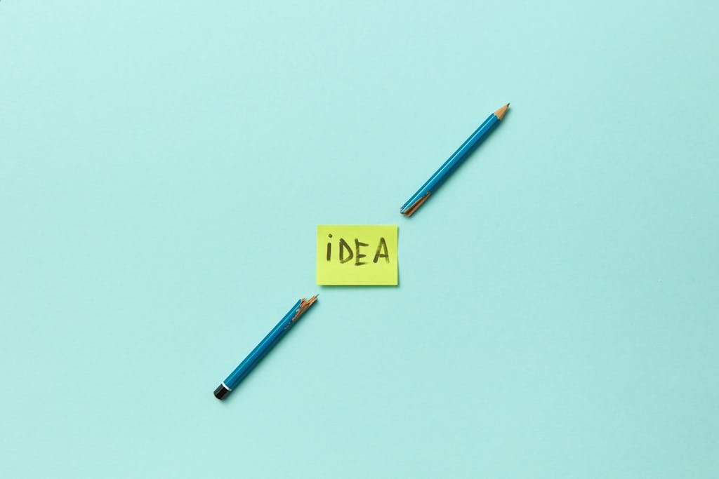 Conceptual photo of a broken pencil with a sticky note labeled 'idea' on a blue background.